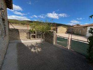 Terraza exterior pavimentada con barbacoa de obra en casa de Osma