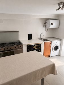 Cocina equipada con fogones de gas y cocina tradicional de leña en casa de Osma