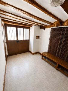 Entrada de casa tradicional en Osma con vigas de madera vistas y puerta de doble hoja