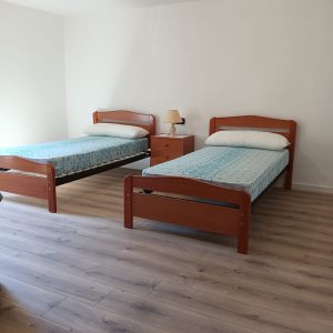 Dormitorio con dos camas individuales y suelo de madera en casa de pueblo en Laño, Condado de Treviño