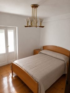 Dormitorio principal de casa de pueblo en Osma con suelo de madera y luz natural