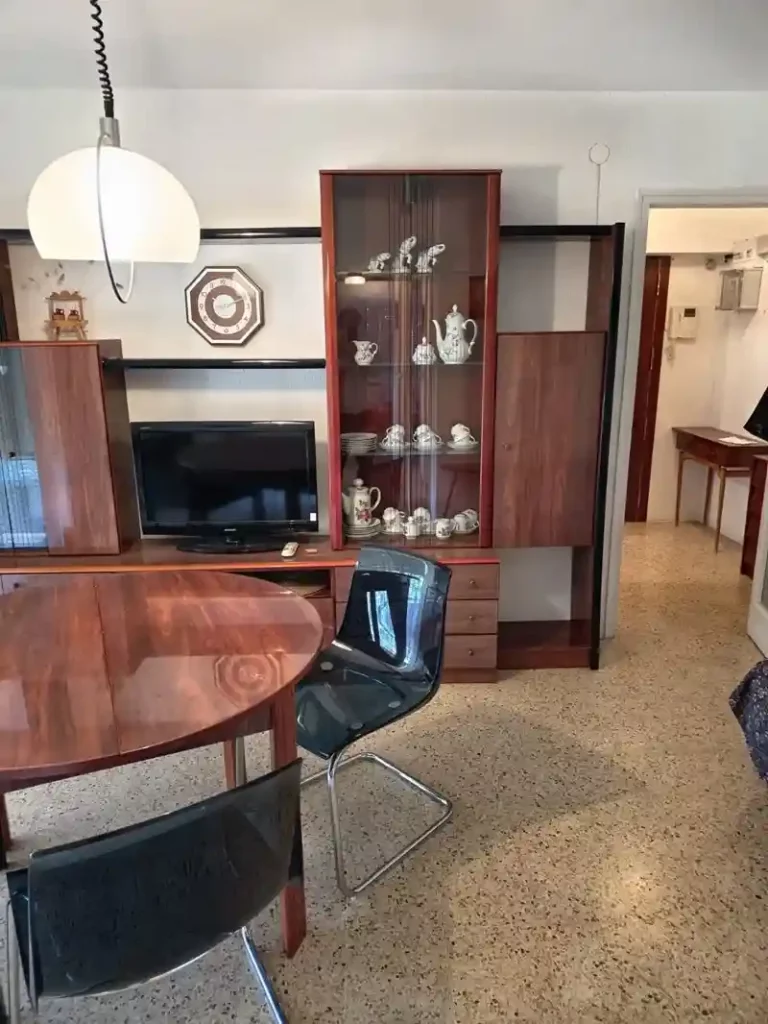 Salón clásico con mobiliario de madera y vajilla decorativa — vivienda antes de reforma por InDôma Pamplona